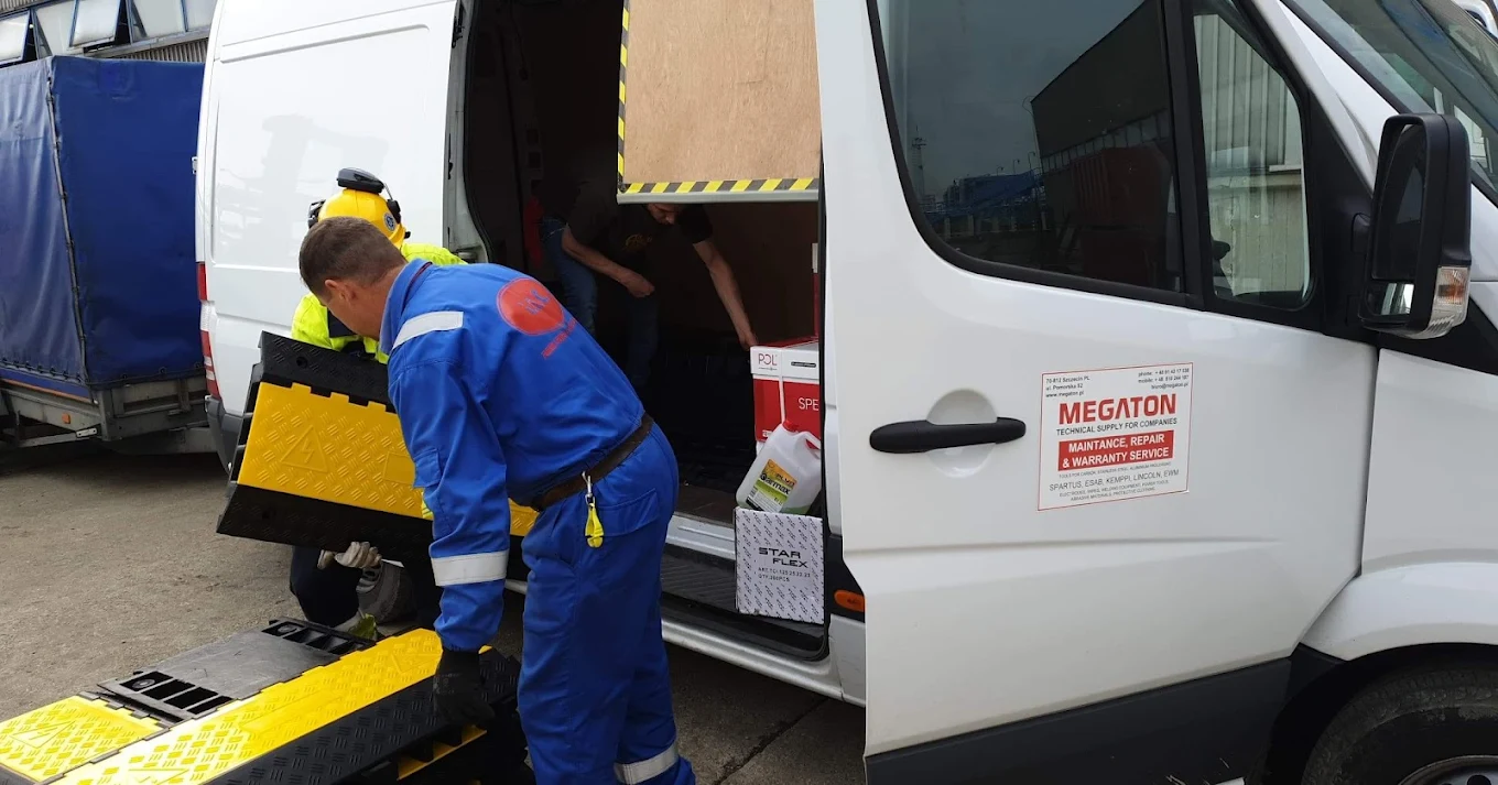 Pracownik przygotowujący specjalistyczny sprzęt do dostawy z samochodu Megaton